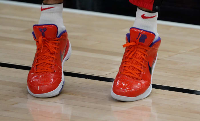View of orange and purple Nike Kobe shoes.